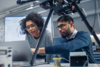 Engineer pointing at a laptop screen and talking to a safety colleague