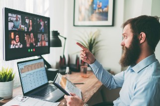 Safety instructor with a beard holding a spreadsheet and leading an online course