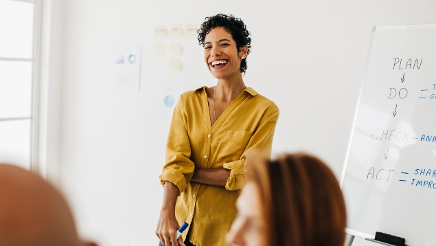 Safety professional woman smiling and giving a presentation to her team