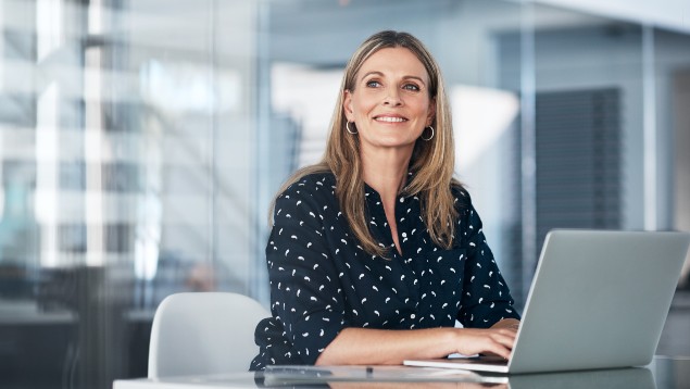 Safety professional woman smiling and working at a computer