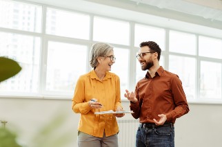 Two professionals smiling and talking in their office