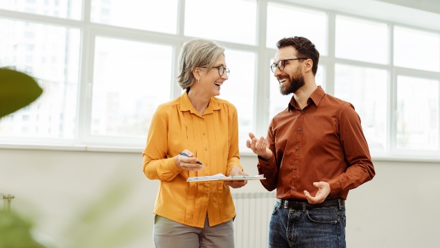 Two professionals smiling and talking in their office