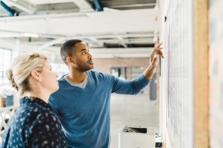 Two safety colleagues using a whiteboard in the office