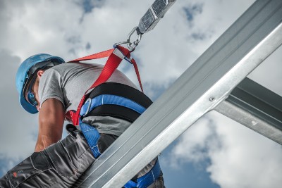 Construction worker harnessed on a steel frame building