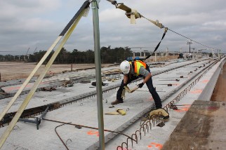 Worker wearing a hardhat and harness on a job site