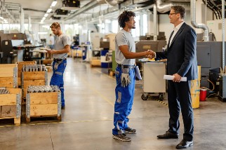 Safety professional shaking hands with a factory worker 