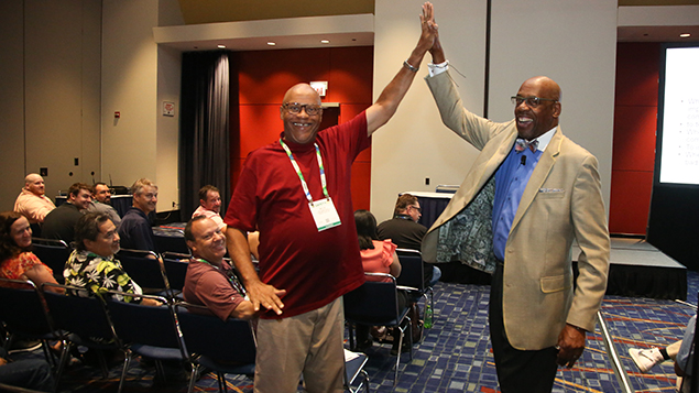 Two ASSP members high five before a conference session